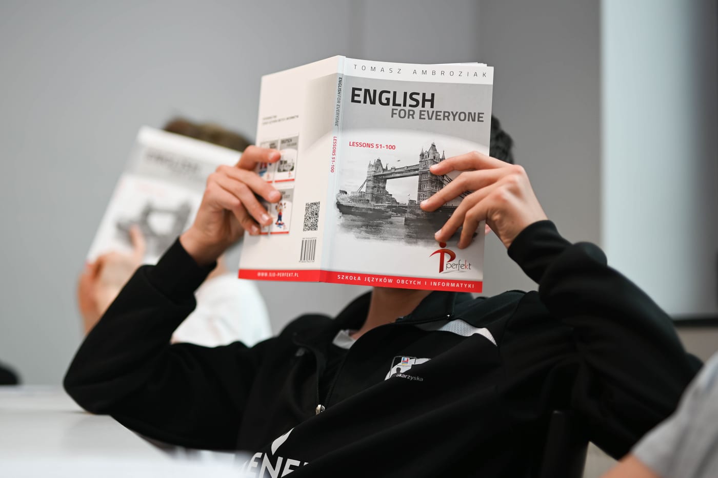 Uczeń czyta podręcznik English for Everyone wydany przez Szkołę Perfekt